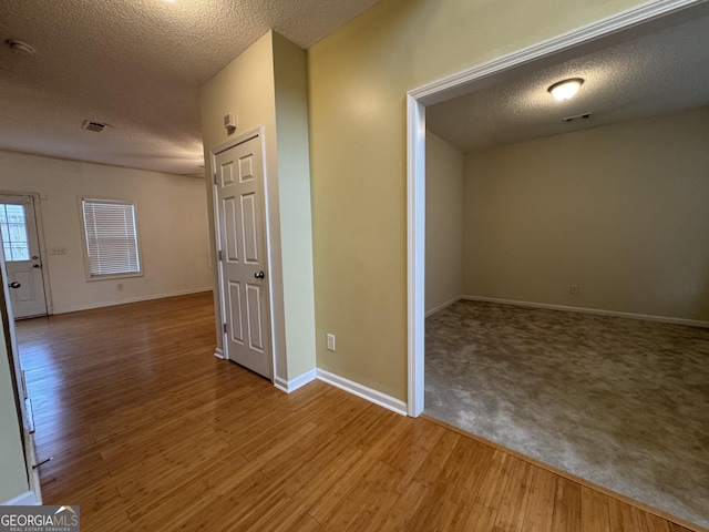 hall featuring hardwood / wood-style floors and a textured ceiling