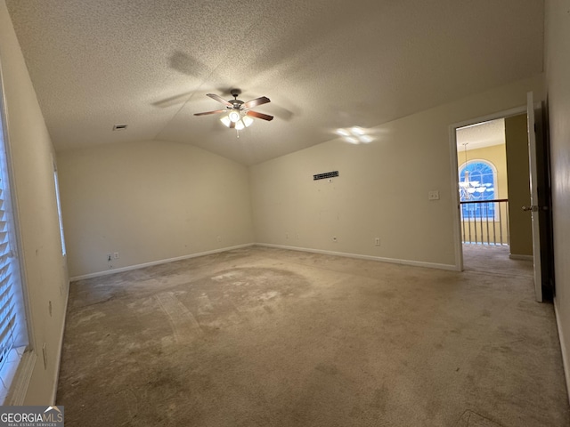 empty room featuring lofted ceiling, a textured ceiling, carpet, and ceiling fan