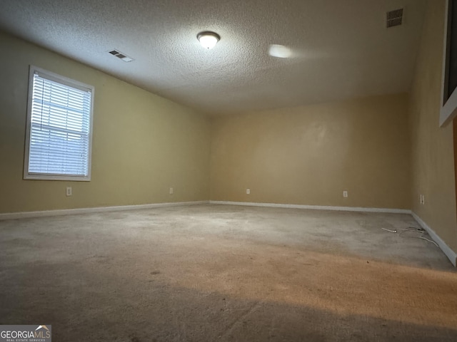 carpeted spare room featuring a textured ceiling