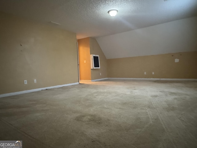 bonus room featuring lofted ceiling and a textured ceiling