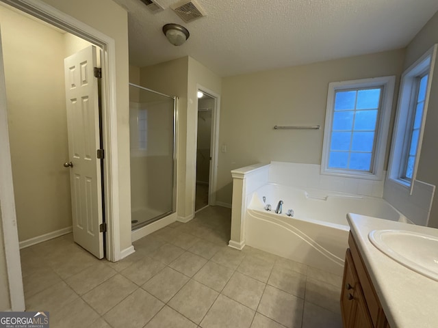 bathroom featuring tile patterned flooring, vanity, separate shower and tub, and a textured ceiling