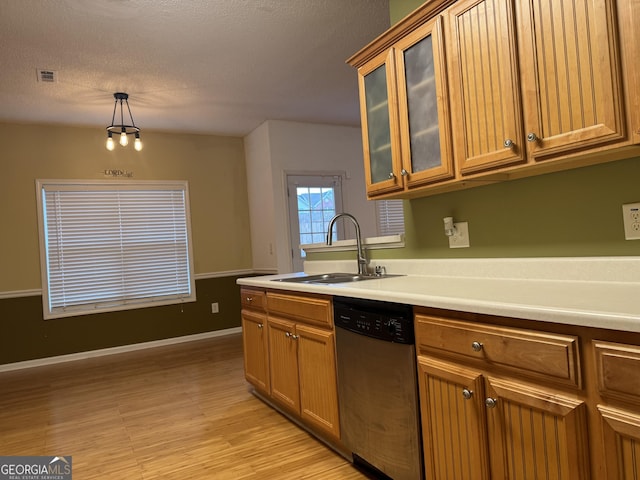 kitchen with sink, hanging light fixtures, a textured ceiling, dishwasher, and light hardwood / wood-style floors