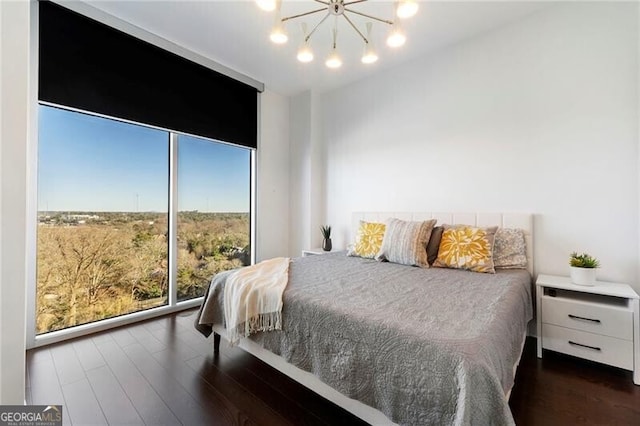 bedroom with expansive windows, dark hardwood / wood-style floors, and an inviting chandelier