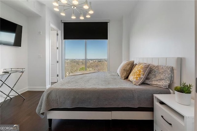 bedroom with dark hardwood / wood-style flooring and a chandelier