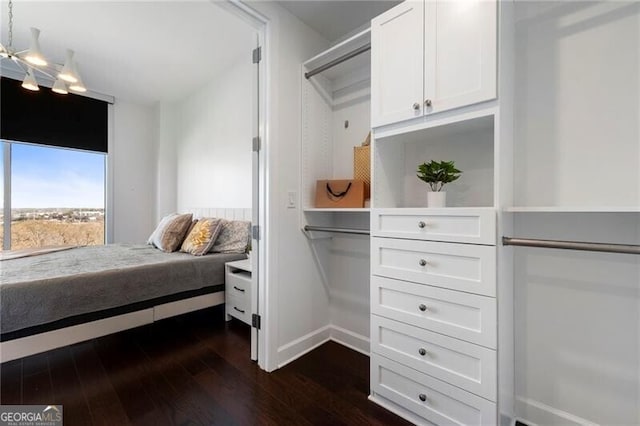 bedroom with dark wood-type flooring and an inviting chandelier