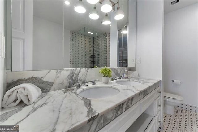 bathroom featuring a shower with shower door, tile patterned floors, toilet, and vanity