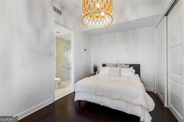 bedroom featuring a closet, dark hardwood / wood-style floors, and ensuite bath