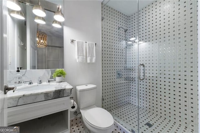 bathroom with toilet, vanity, tile patterned flooring, and a shower with door