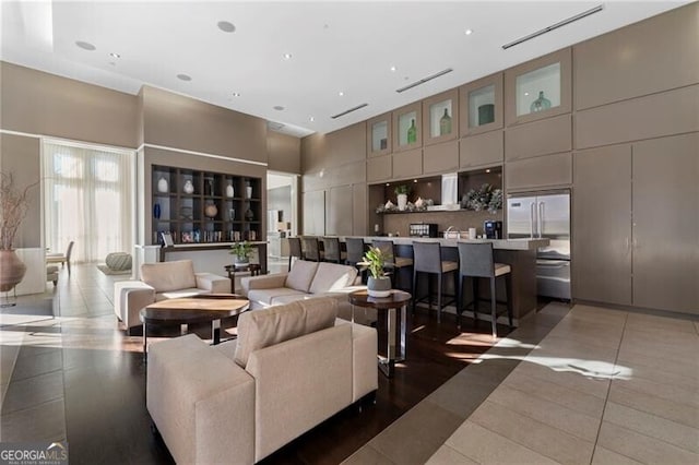 living room featuring a high ceiling and dark tile patterned flooring