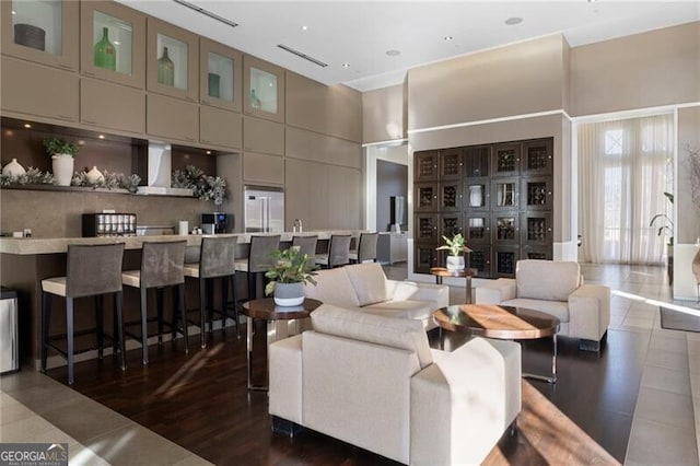 living room with a high ceiling and dark tile patterned flooring