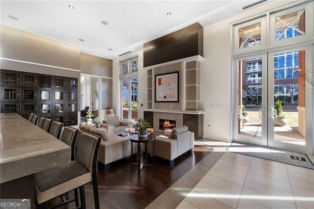 living room featuring plenty of natural light, built in features, french doors, and tile patterned flooring