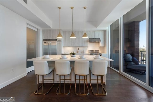 kitchen featuring built in refrigerator, a center island, pendant lighting, and range