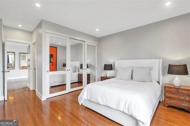 bedroom featuring connected bathroom, wood-type flooring, and french doors