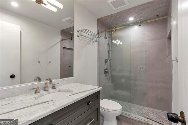 bathroom featuring walk in shower, vanity, and toilet