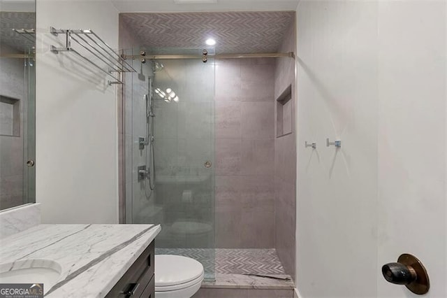 bathroom with vanity, an enclosed shower, and toilet