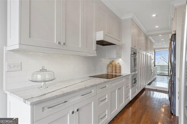 kitchen with black electric cooktop, white cabinetry, and oven