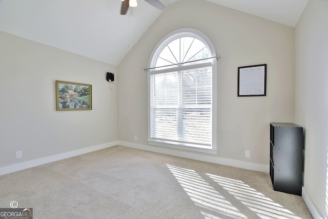 spare room with high vaulted ceiling, light carpet, and ceiling fan