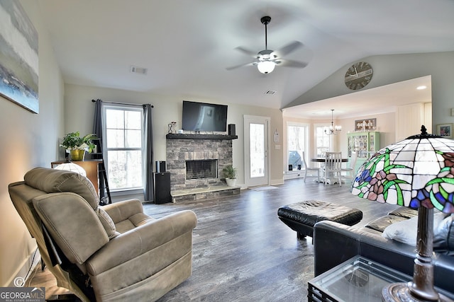 living room featuring vaulted ceiling, dark hardwood / wood-style flooring, plenty of natural light, and a fireplace