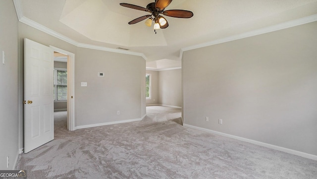 empty room featuring light carpet, ornamental molding, and a raised ceiling