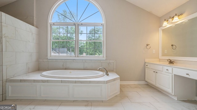 bathroom with a washtub, vanity, and lofted ceiling