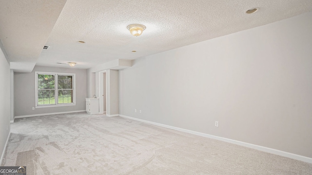 carpeted empty room with a textured ceiling