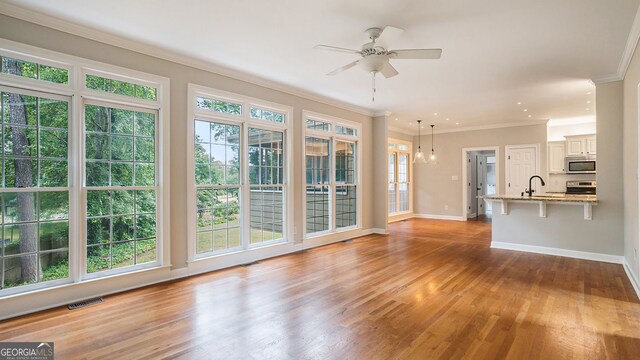 living room featuring ceiling fan, light wood-type flooring, and crown molding