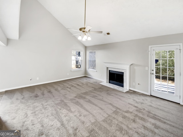 unfurnished living room with light carpet, ceiling fan, a fireplace, and high vaulted ceiling