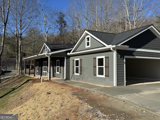 view of side of property featuring covered porch and a garage