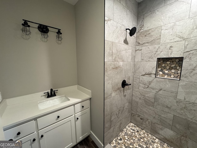 bathroom featuring a tile shower and vanity