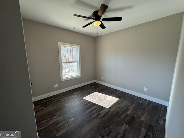 spare room with ceiling fan and dark hardwood / wood-style flooring