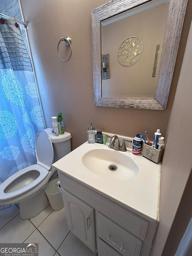 bathroom with toilet, vanity, and tile patterned floors