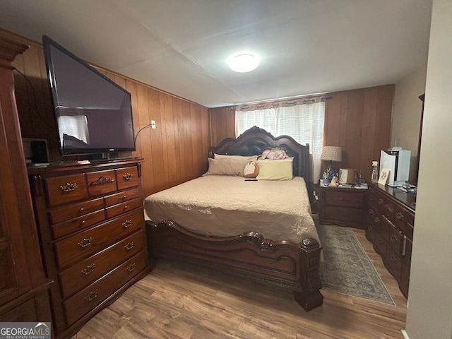 bedroom featuring wood-type flooring and wooden walls