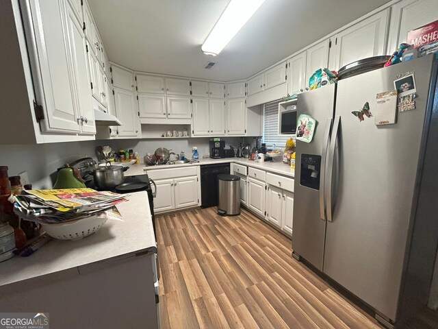 kitchen featuring electric stove, dishwasher, sink, hardwood / wood-style flooring, and white cabinets