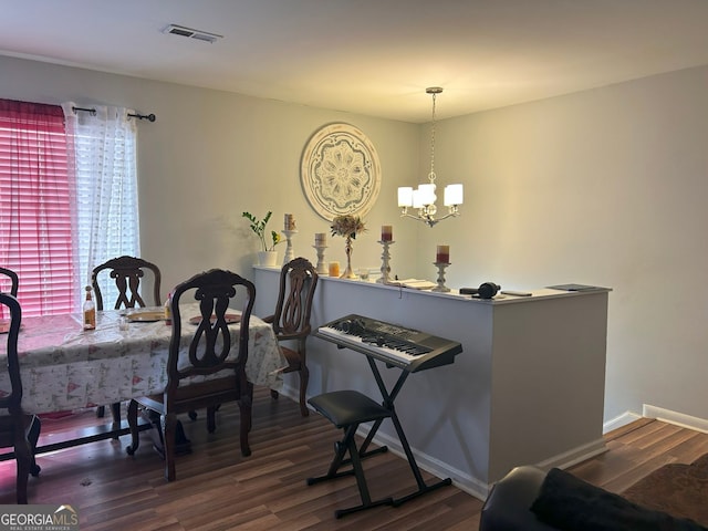 dining room featuring dark hardwood / wood-style flooring and a chandelier