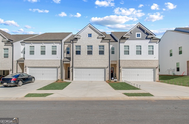 multi unit property featuring a residential view, brick siding, driveway, and an attached garage