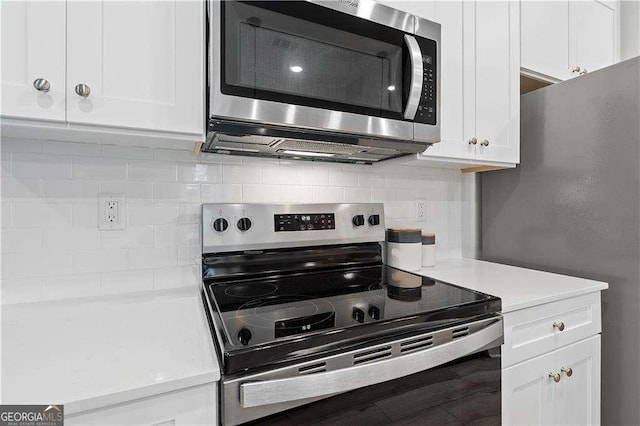 kitchen with stainless steel appliances, light countertops, white cabinetry, and decorative backsplash