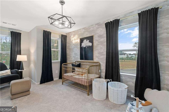 carpeted bedroom with wallpapered walls, visible vents, multiple windows, and baseboards