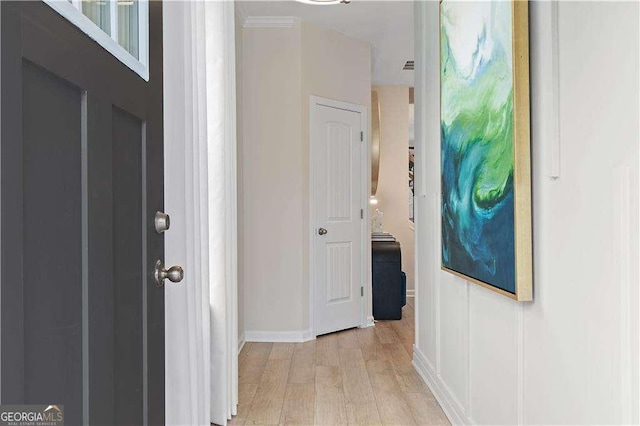 hallway featuring light wood-style flooring and baseboards