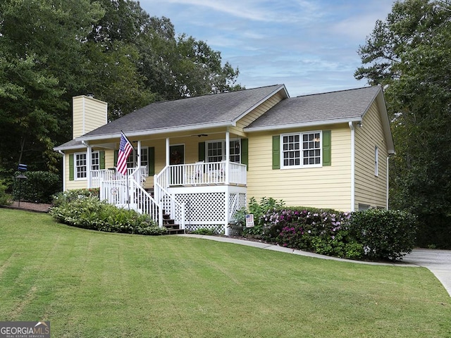 single story home featuring covered porch and a front yard