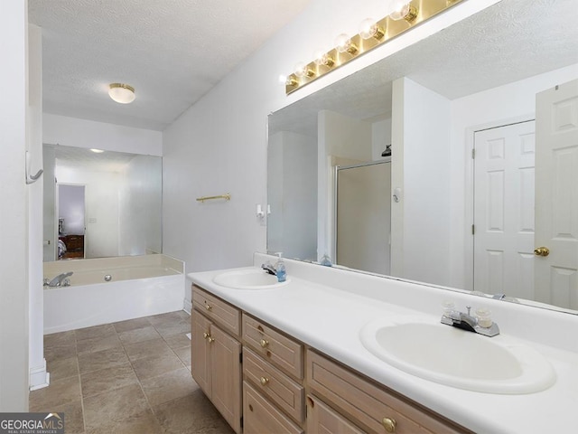 bathroom featuring a textured ceiling, vanity, and independent shower and bath