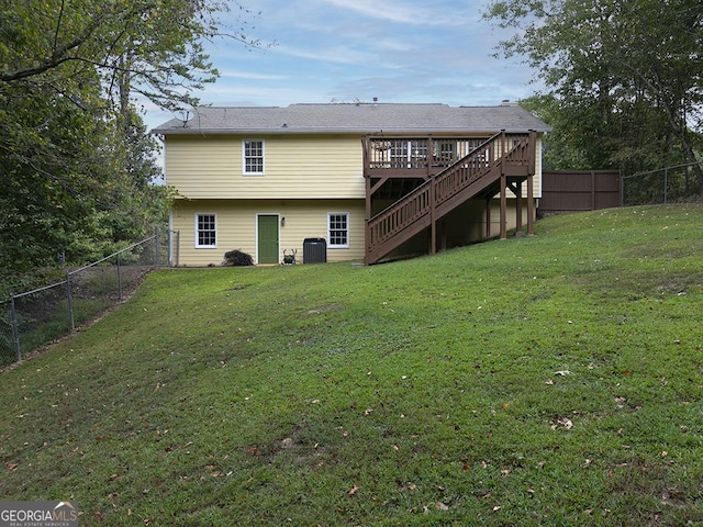 rear view of property with a deck and a lawn