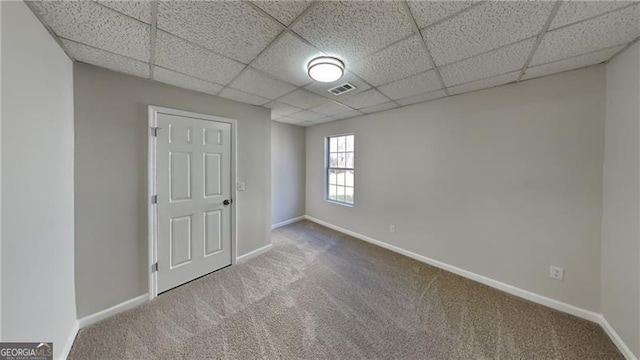 spare room with carpet and a paneled ceiling