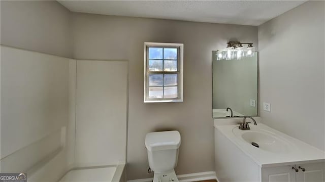 bathroom with toilet, vanity, and walk in shower