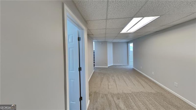 hallway with a drop ceiling and light carpet