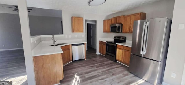 kitchen with appliances with stainless steel finishes, sink, and light hardwood / wood-style floors