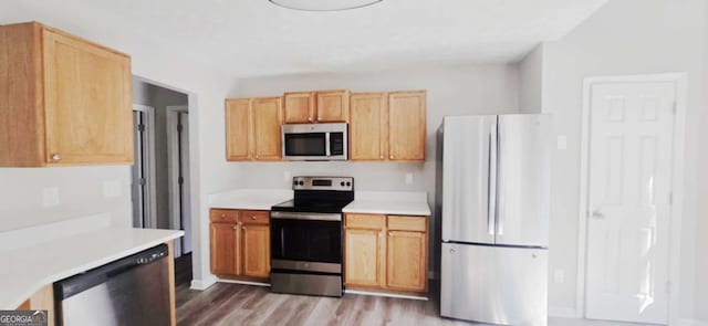 kitchen featuring appliances with stainless steel finishes, light brown cabinets, and light hardwood / wood-style flooring