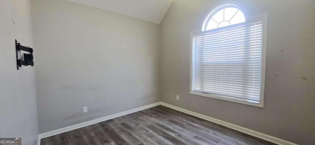 unfurnished room featuring dark wood-type flooring and lofted ceiling