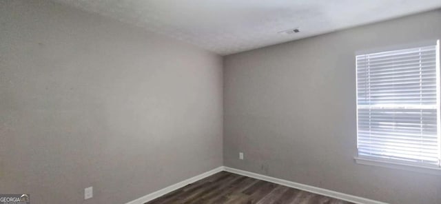 unfurnished room featuring dark hardwood / wood-style flooring