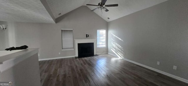 unfurnished living room with vaulted ceiling, ceiling fan, dark hardwood / wood-style flooring, and a textured ceiling