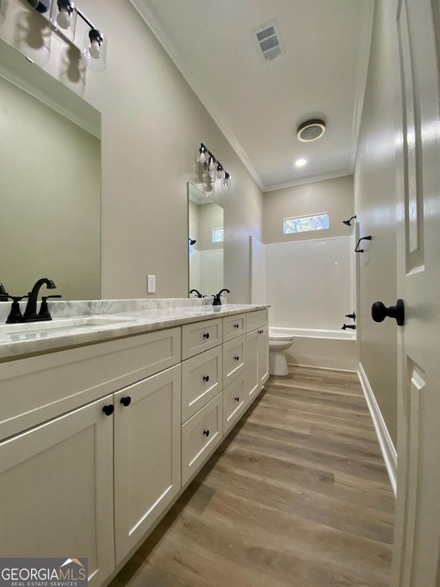 full bathroom with bathing tub / shower combination, wood-type flooring, vanity, toilet, and crown molding